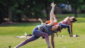 Adults doing yoga in a park3