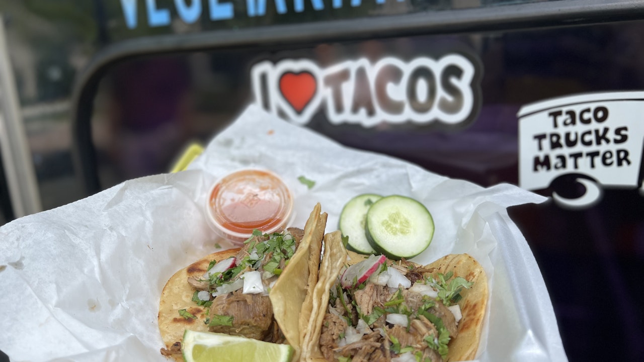 Two tacos in to-go container near International Truck of Tacos1