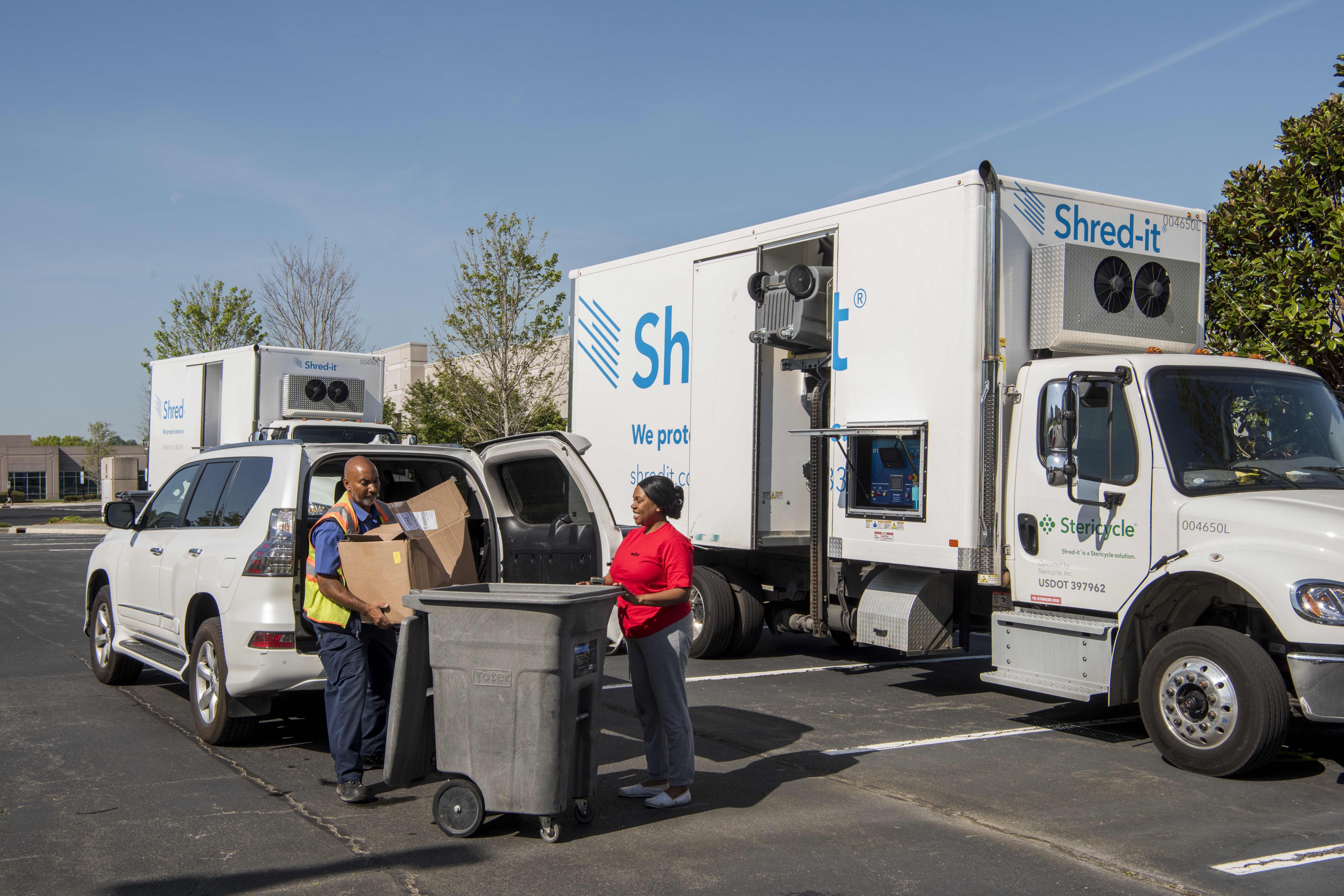 Adults unloading paper from car to shred and recycle1