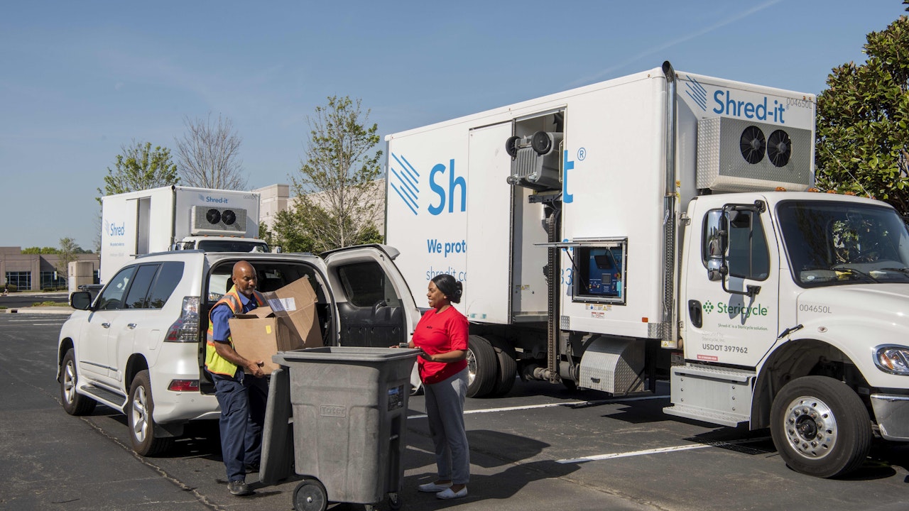 Adults unloading paper from car to shred and recycle1