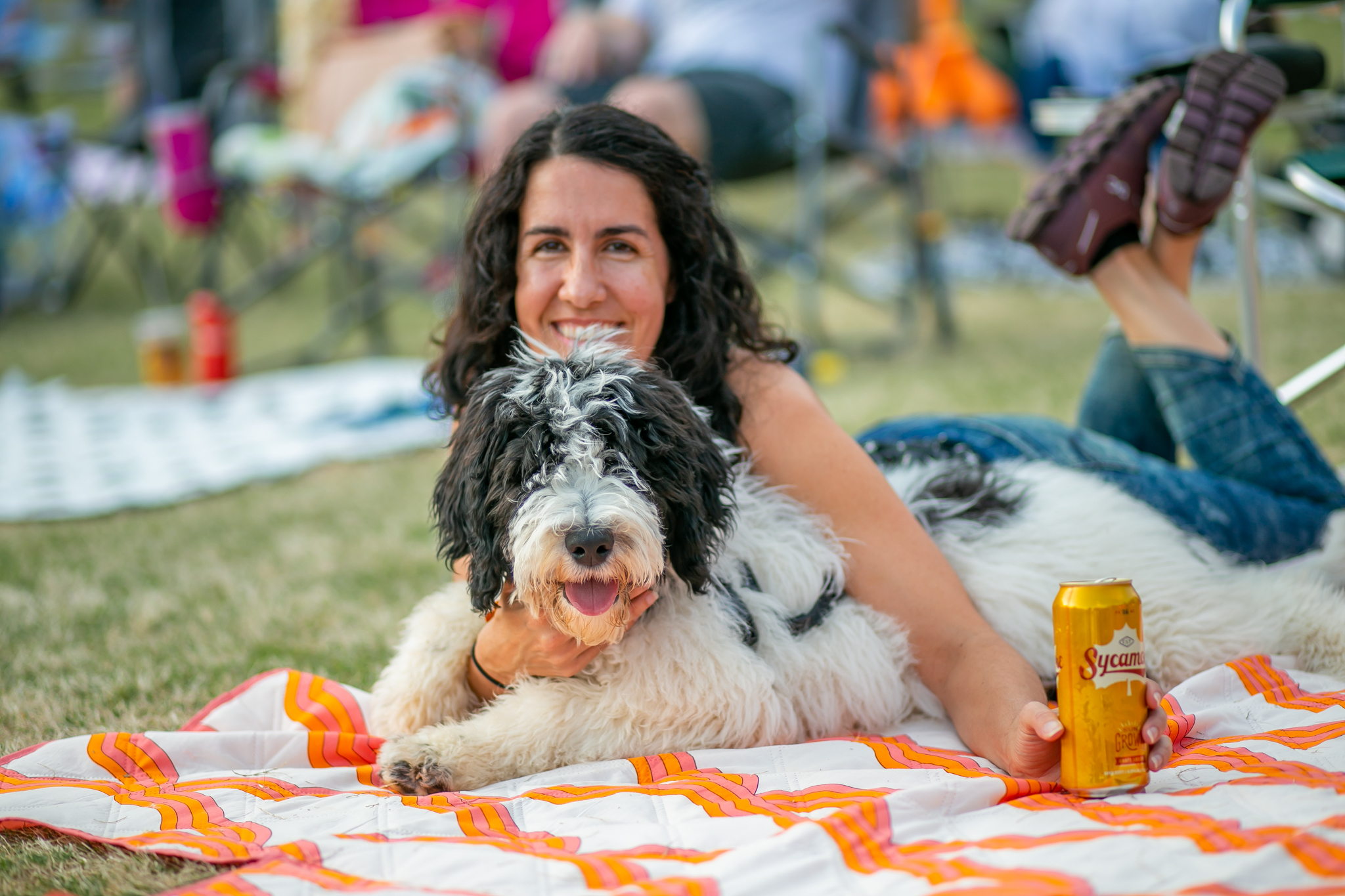 Young woman and dog lay on blanket in park5