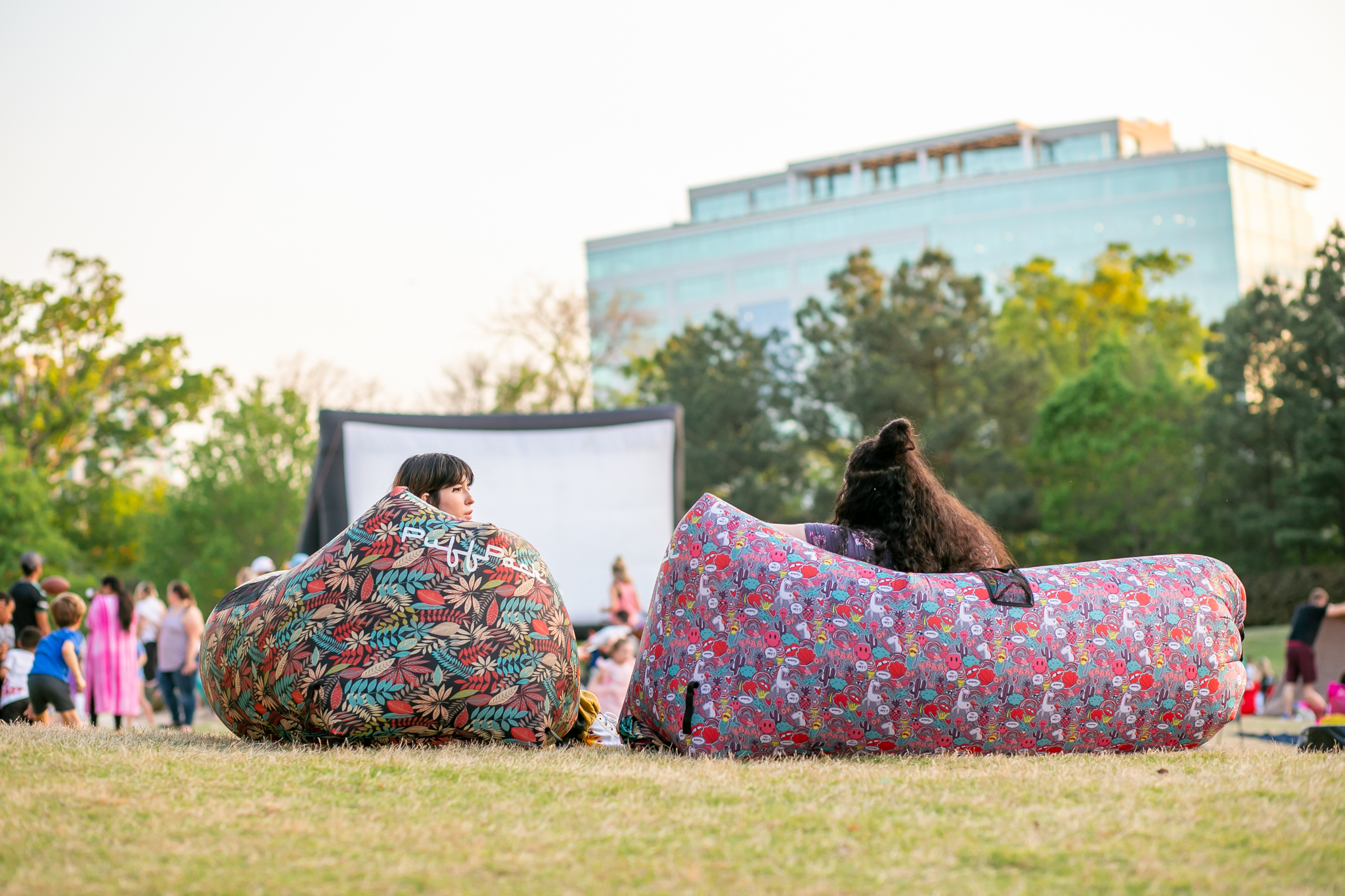 Young people sitting in park to watch a movie on outdoor screen4