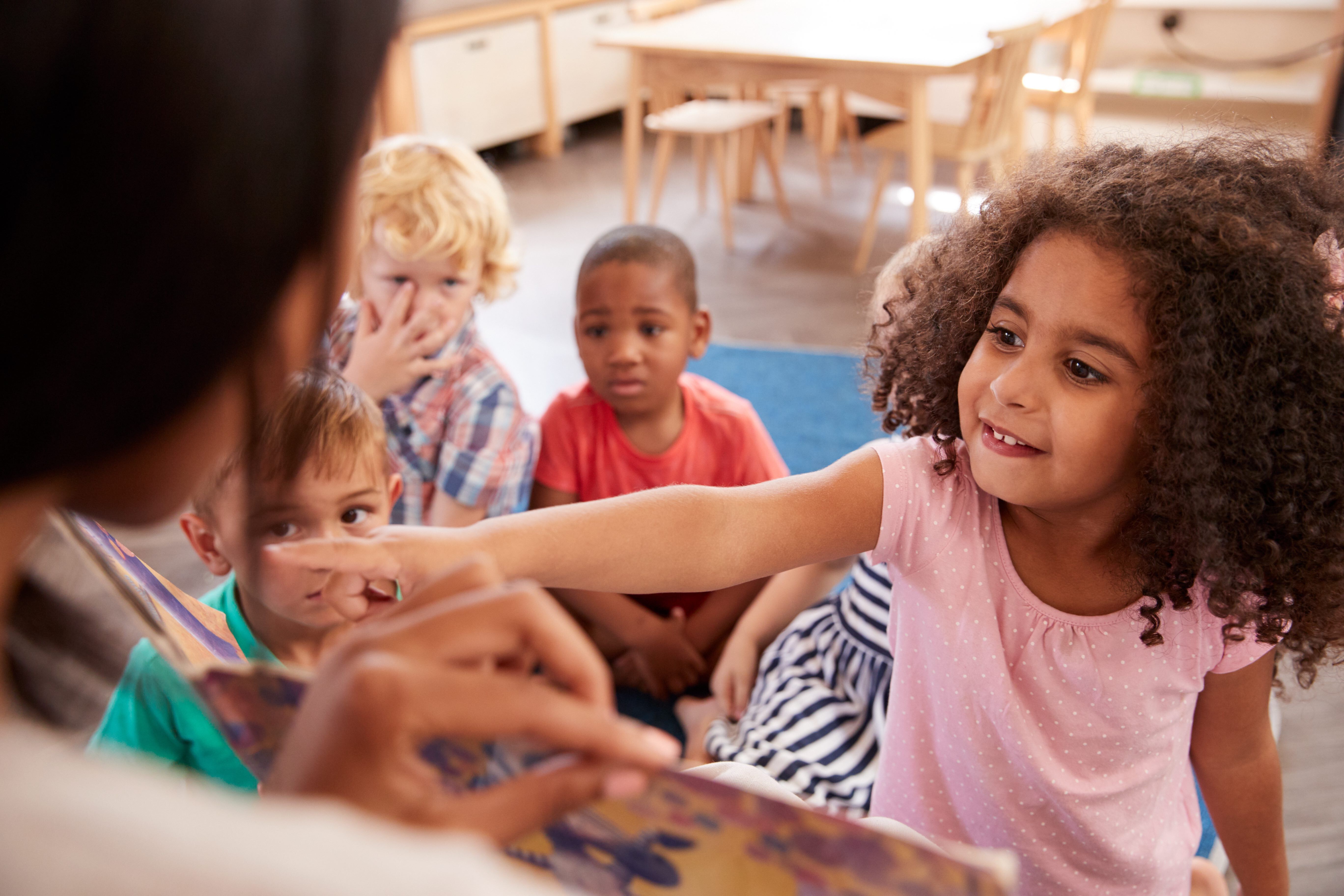 Children reading a book at day care facility