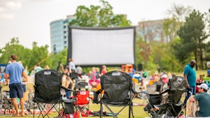 Large screen and guests in outdoor park for movie4